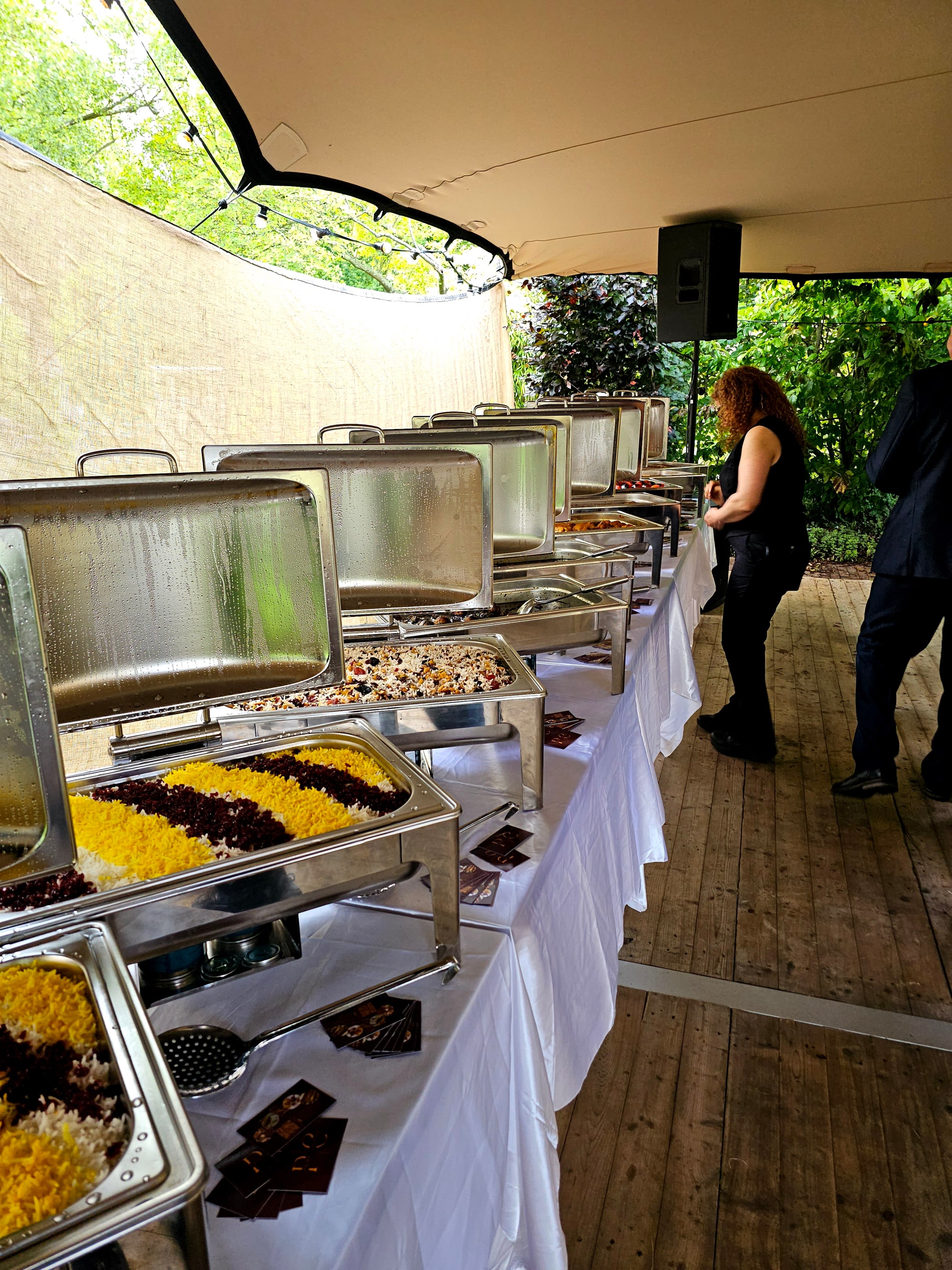 Lange buffetopstelling met saffraanrijst en warme gerechten tijdens een evenement
