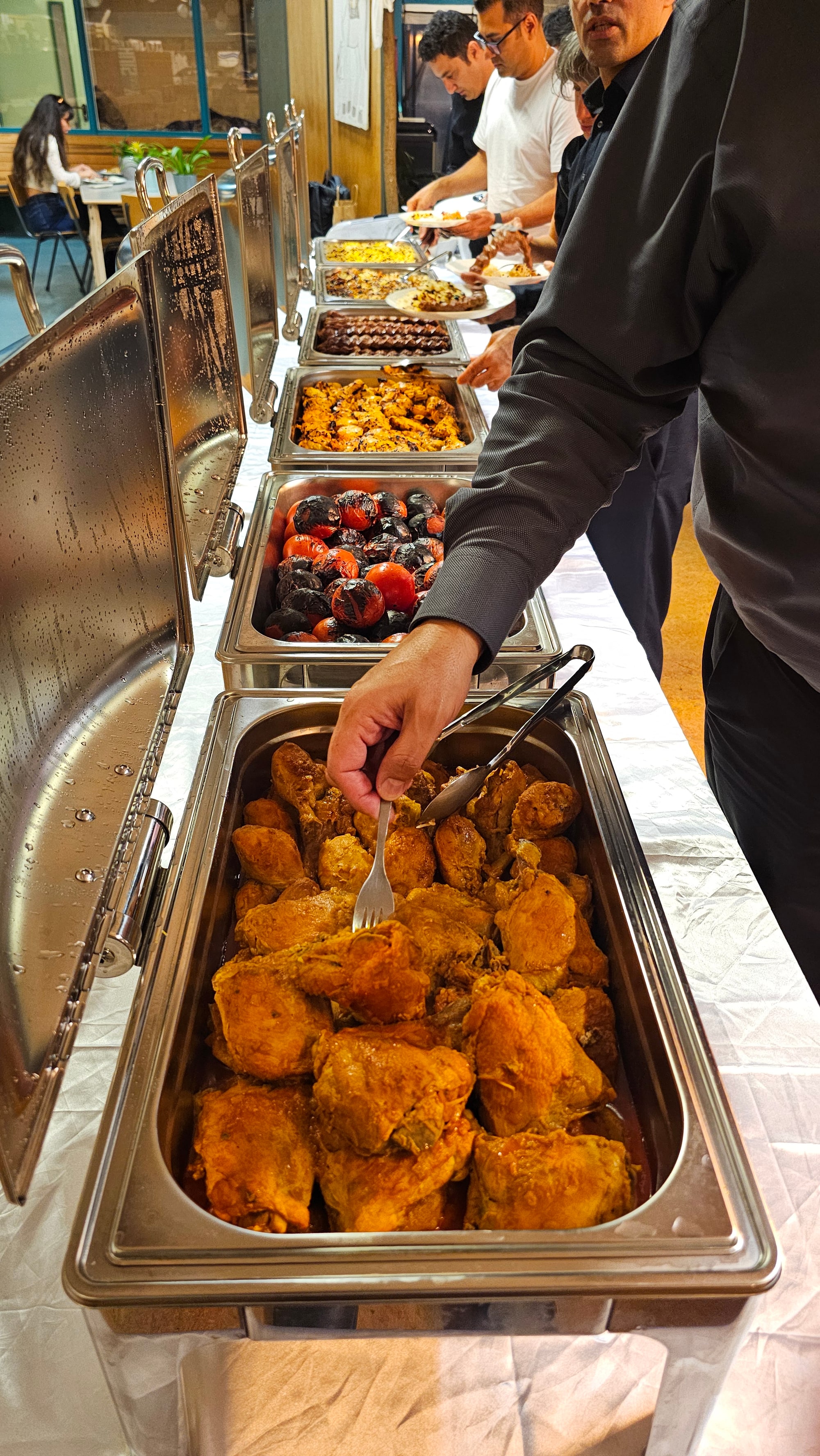 Gasten bedienen zichzelf aan een royaal warm buffet