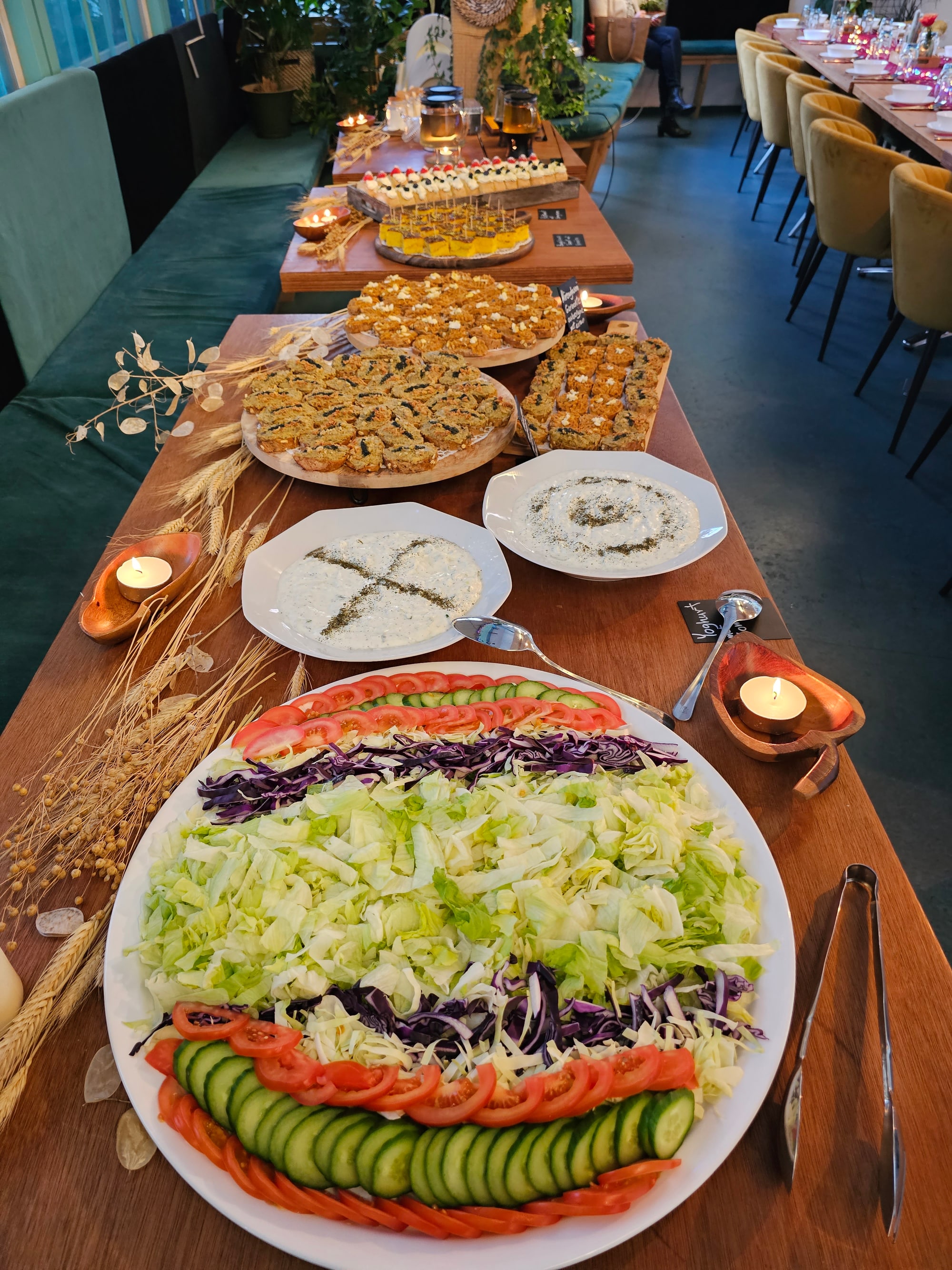 Generous buffet on a long table with salads, dips and bites