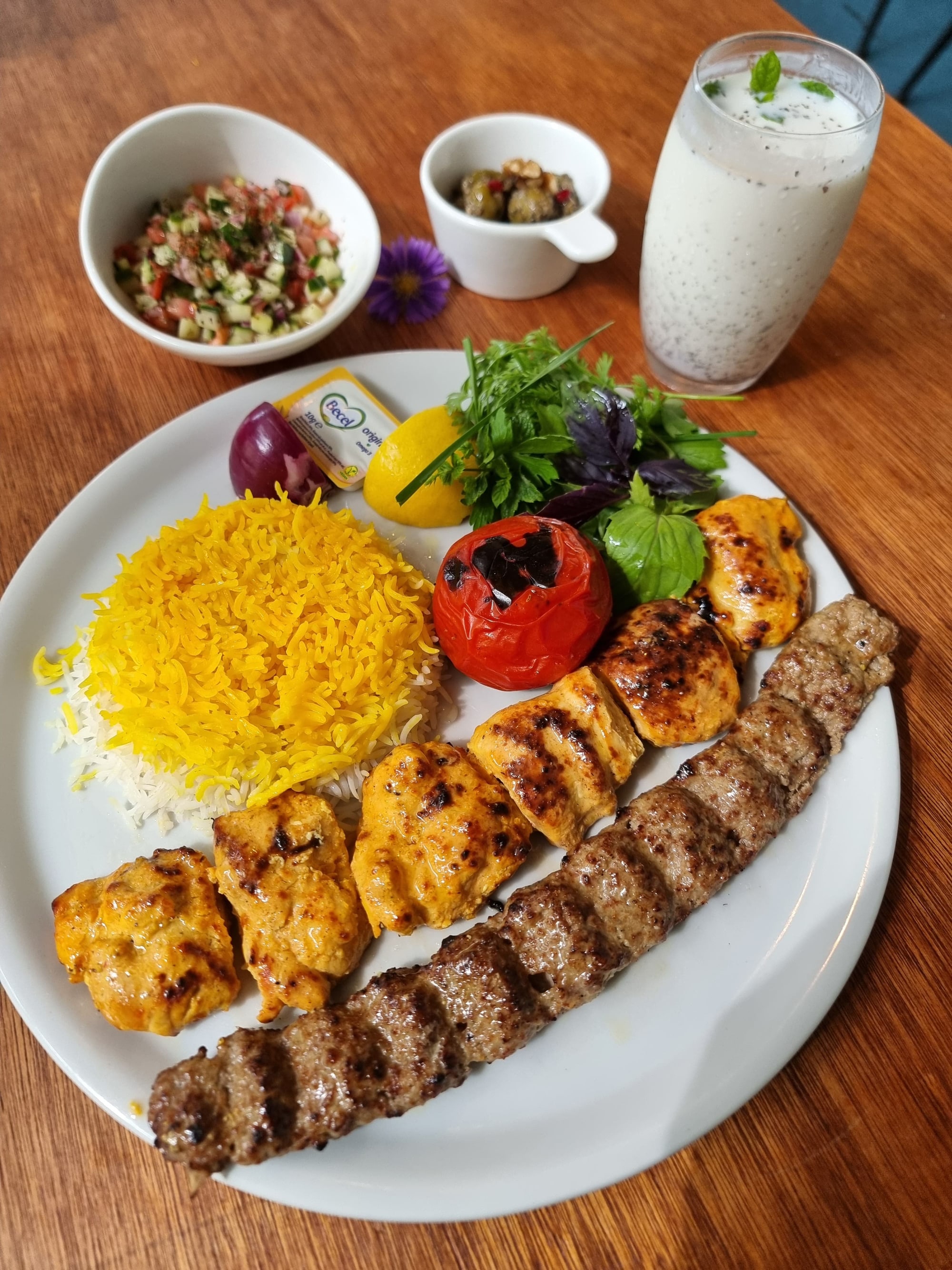 Persian kebabs with saffron rice, grilled tomato and fresh herbs