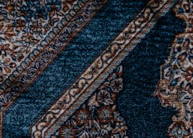 Close-up of a detailed vintage floral carpet design with geometric patterns.